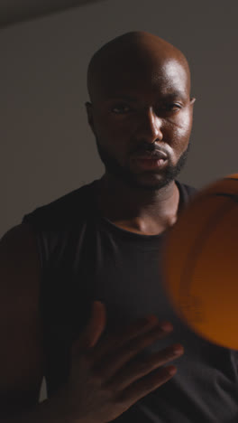 Vertical-Video-Studio-Vertical-Video-Portrait-Shot-Of-Male-Basketball-Player-Throwing-Ball-From-One-Hand-To-The-Other-1